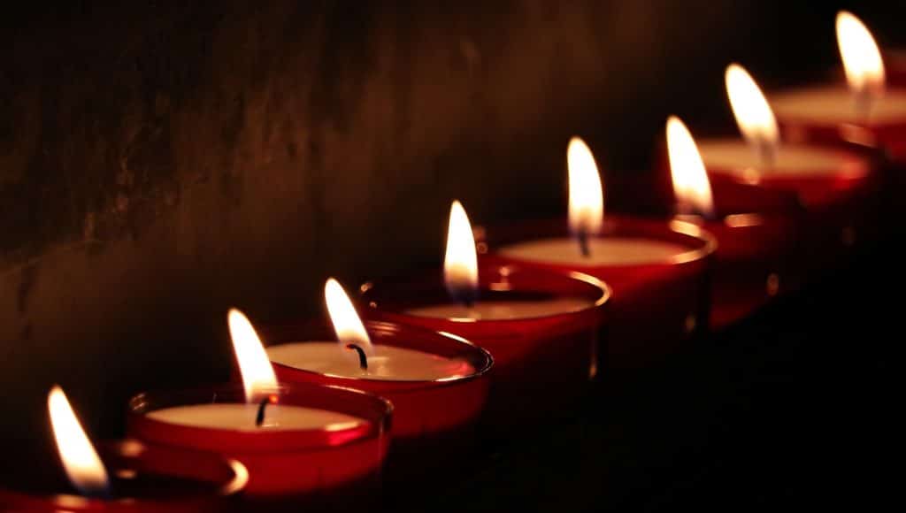 Foto de uma sequência de velas acesas em clima intimista.