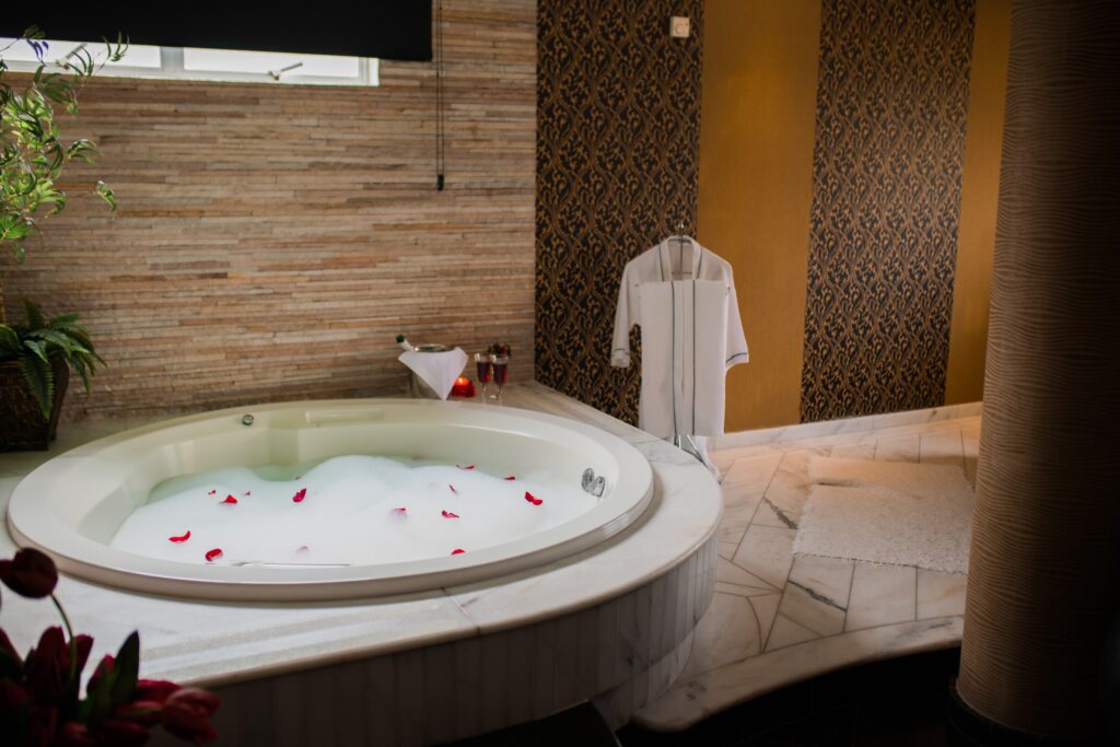 Quarto de motel estilo spa de relaxamento, com banheira e um roupão ao lado.