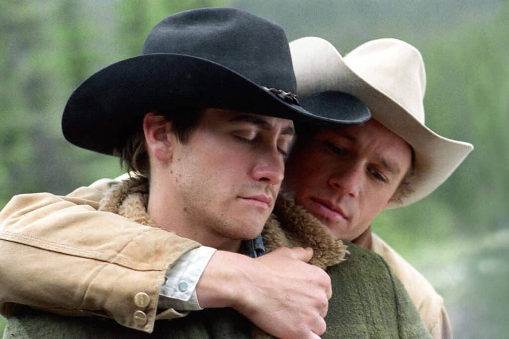 Cena do filme brokeback mountain com os dois cowboys protagonistas se abraçando apaixonadamente